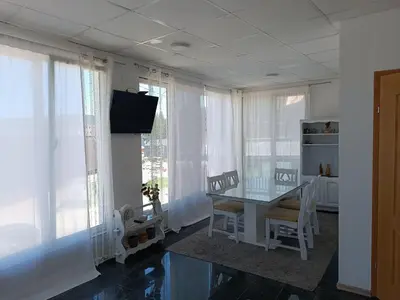 a dining room with a table and chairs and windows at Mountain Relax Vlašić in Vlasic