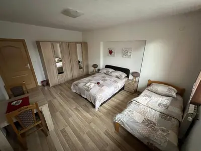 a bedroom with two beds and a table and a door at stari grad in Doboj