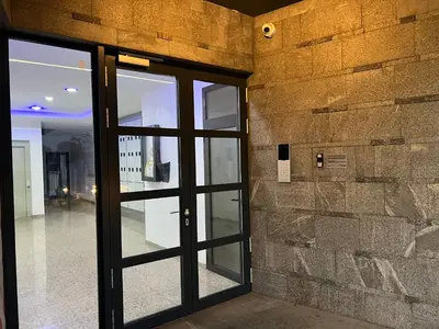 an entrance door to a building with a stone wall at Apartman Sara in Zenica