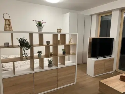 a living room with a flat screen tv and wooden shelves at Apartman Sara in Zenica