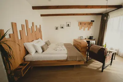 a bedroom with a bed with a wooden headboard at Zemunice Knezevic in Banja Luka