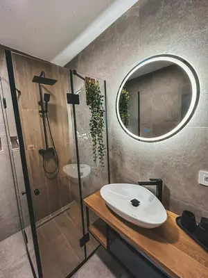 a bathroom with a sink and a shower and a mirror at Zemunice Knezevic in Banja Luka