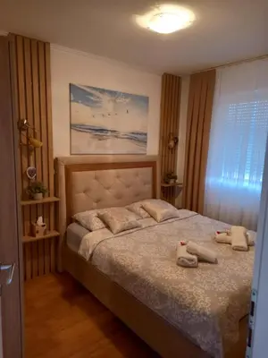 a bedroom with a bed with two stuffed animals on it at Apartman Jana in Doboj