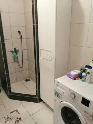 a washing machine in a bathroom with a shower at Apartman Jana in Doboj