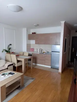 a kitchen and living room with a table and a refrigerator at Apartman Jana in Doboj