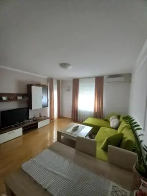 a living room with a green couch and a television at Apartman Jana in Doboj