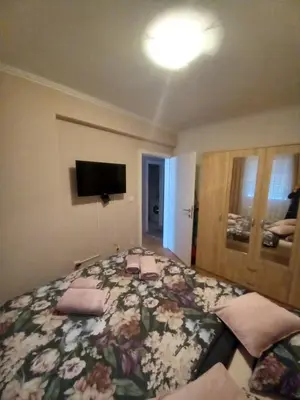 a bedroom with a large bed with flowers on it at Apartman Jana in Doboj