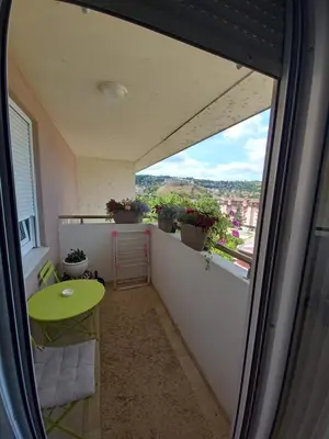 a balcony with a green table and potted plants at Apartman Jana in Doboj