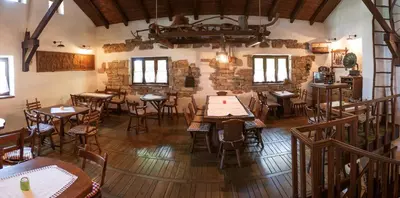 a restaurant with tables and chairs in a room at Farm Stay Čardaklije in Kulen Vakuf