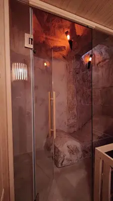 a shower with a glass door in a cave at Farm Stay Čardaklije in Kulen Vakuf