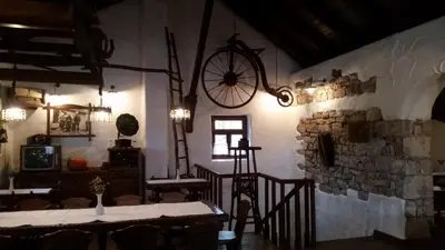 a dining room with a table and a clock on the wall at Farm Stay Čardaklije in Kulen Vakuf