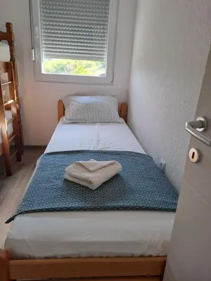 a small bedroom with a bed with a towel on it at Vikendica sa bazenom Staša in Banja Luka