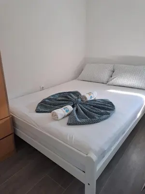 a bed with a blanket and two towels on it at Vikendica sa bazenom Staša in Banja Luka