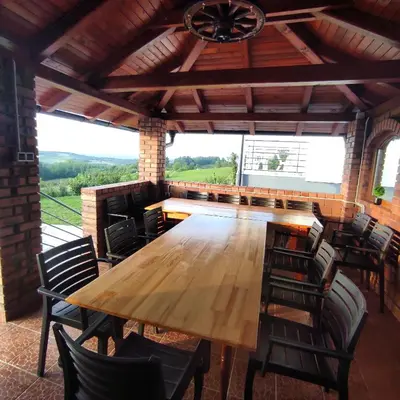 a large wooden table in a room with chairs at Vikendica sa bazenom Staša in Banja Luka