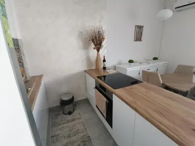 a kitchen with white cabinets and a counter top at APARTMAN KRPELJ Banja Luka in Budžak