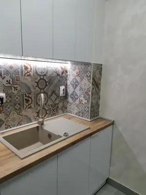 a kitchen with a sink and a tile wall at APARTMAN KRPELJ Banja Luka in Budžak