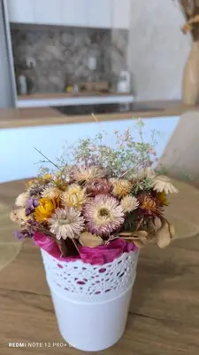 a bouquet of flowers in a white basket on a table at APARTMAN KRPELJ Banja Luka in Budžak