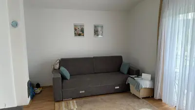 a living room with a brown couch and a window at B&B Hills Bihać in Bihać