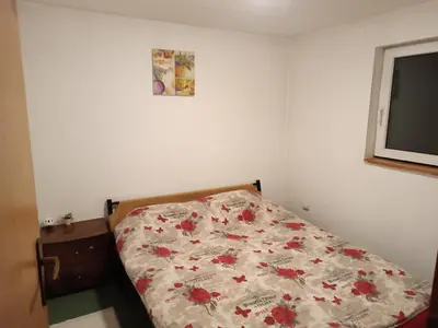 a bedroom with a bed with a floral comforter at Mountain Apartment Vlašić Babanovac in Vlasic
