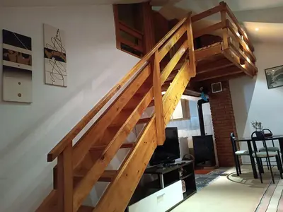 a wooden staircase in a room with a living room at Mountain Apartment Vlašić Babanovac in Vlasic