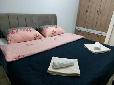 a bed with pink sheets and towels on it at Apartman-Centar-Bugojno in Bugojno