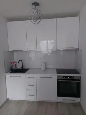 a kitchen with white cabinets and a black oven at Apartman-Centar-Bugojno in Bugojno