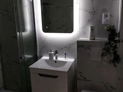 a white bathroom with a sink and a mirror at Apartman-Centar-Bugojno in Bugojno