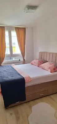 a bedroom with two beds and two windows at Apartman-Centar-Bugojno in Bugojno