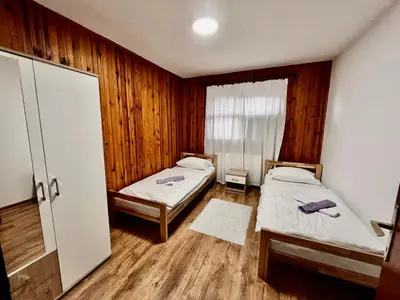 two beds in a room with wooden walls at Kuća za odmor Bilić in Sopot