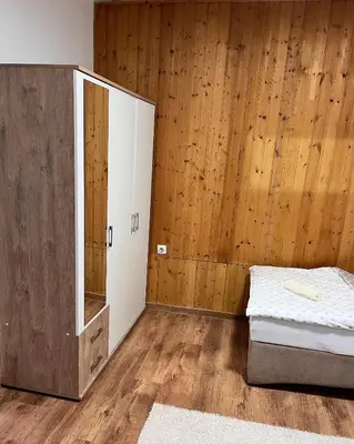 a bedroom with a bed and a wooden wall at Kuća za odmor Bilić in Sopot