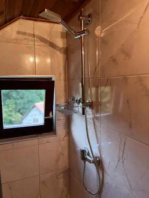 a shower in a bathroom with a window at Kuća za odmor Bilić in Sopot