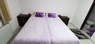 a bedroom with a bed with purple pillows at Apartman Delic in Lukavac