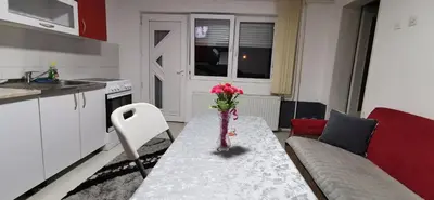 a living room with a table with a vase of flowers on it at Apartman Delic in Lukavac