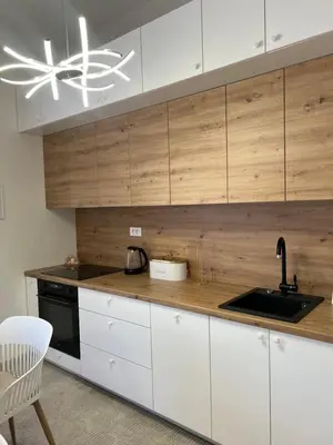 a kitchen with white cabinets and a sink and a ceiling at Apartment Magnolia in Banja Luka