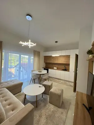 a living room with two tables and a kitchen at Apartment Magnolia in Banja Luka