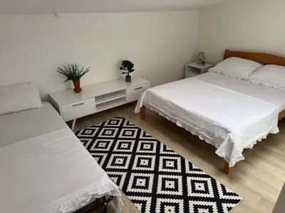a bedroom with two beds and a rug at Apartment Star in Jajce