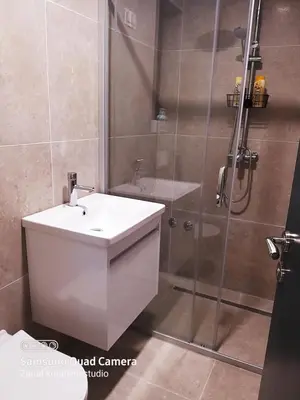 a bathroom with a white sink and a shower at Apartman Košuta in Laktaši