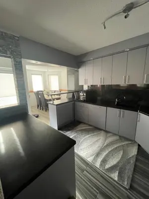 a kitchen with white cabinets and a table in it at Villa ADA in Jajce