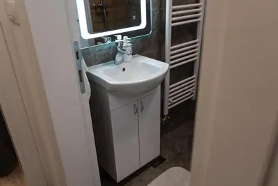a bathroom with a white sink and a window at Lux Apartment III Prijedor in Prijedor