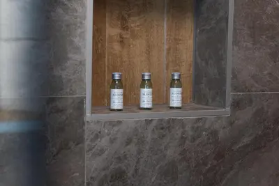 three bottles of wine sitting on a shelf in a bathroom at Lux Apartment III Prijedor in Prijedor