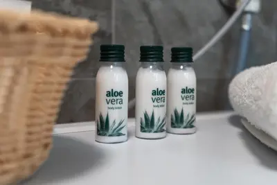 three bottles of aloe vera bottles on a counter at Lux Apartment III Prijedor in Prijedor