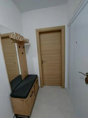 a dressing room with a mirror and a wooden door at Apartman Centar Kozarska Dubica in Bosanska Dubica