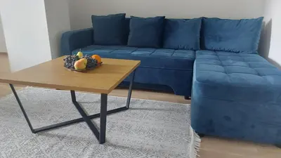 a blue couch and a table with a bowl of fruit at Apartman Centar Kozarska Dubica in Bosanska Dubica
