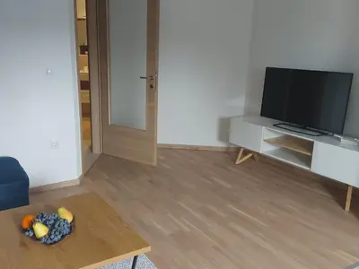 a living room with a television and a bowl of fruit on a table at Apartman Centar Kozarska Dubica in Bosanska Dubica