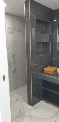 a bathroom with a shower with a counter and a sink at Central Maisonette in Banja Luka