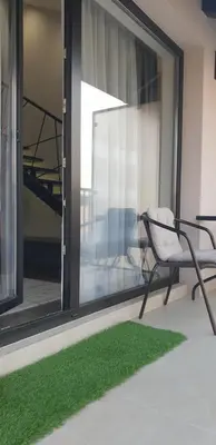 a chair sitting on a balcony with green grass at Central Maisonette in Banja Luka