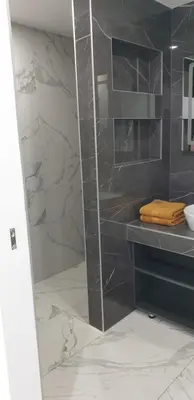 a bathroom with a shower with a glass door at Central Maisonette in Banja Luka