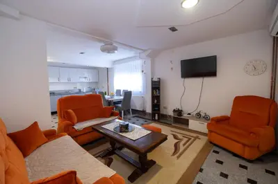 a living room with orange chairs and a table at GOOD People in Bihać