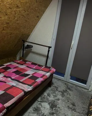 a bedroom with a bed with a checkered blanket at Vikendica Amra i Indir in Travnik