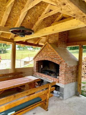 a brick oven with a table and a bench at Vikendica Amra i Indir in Travnik